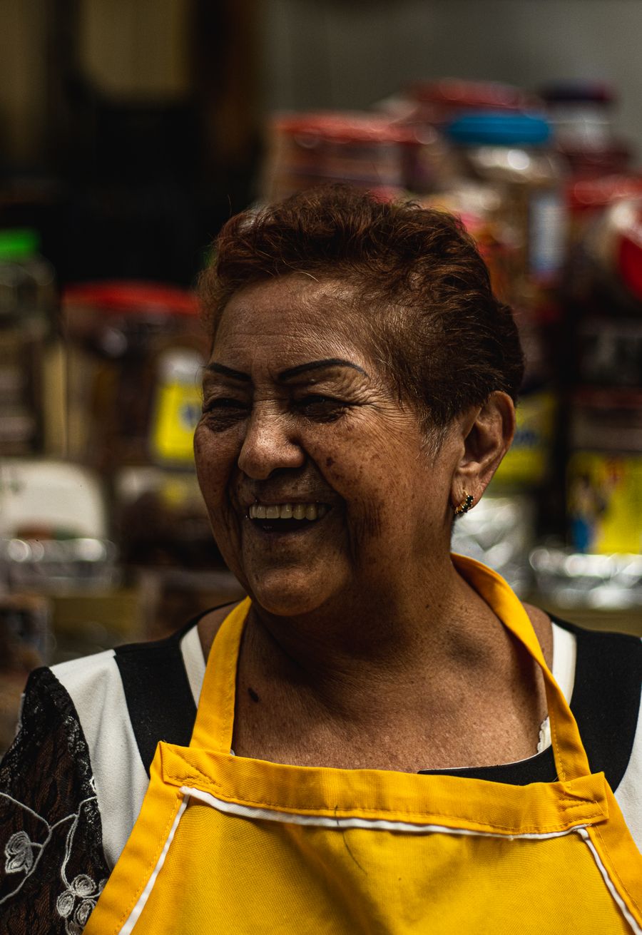 Cocinera sonriendo en su puesto de comida