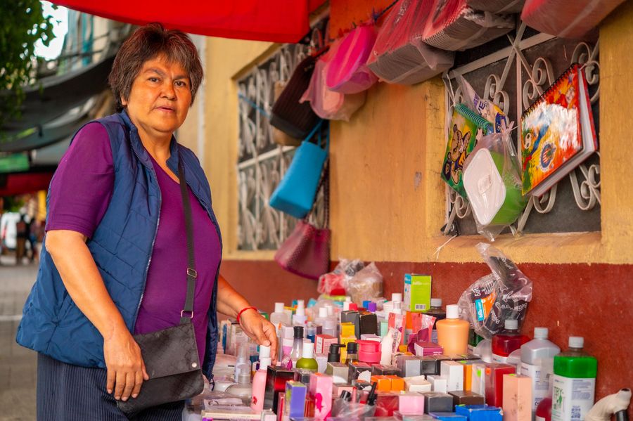 Vendedora sonriendo en su puesto de mercería