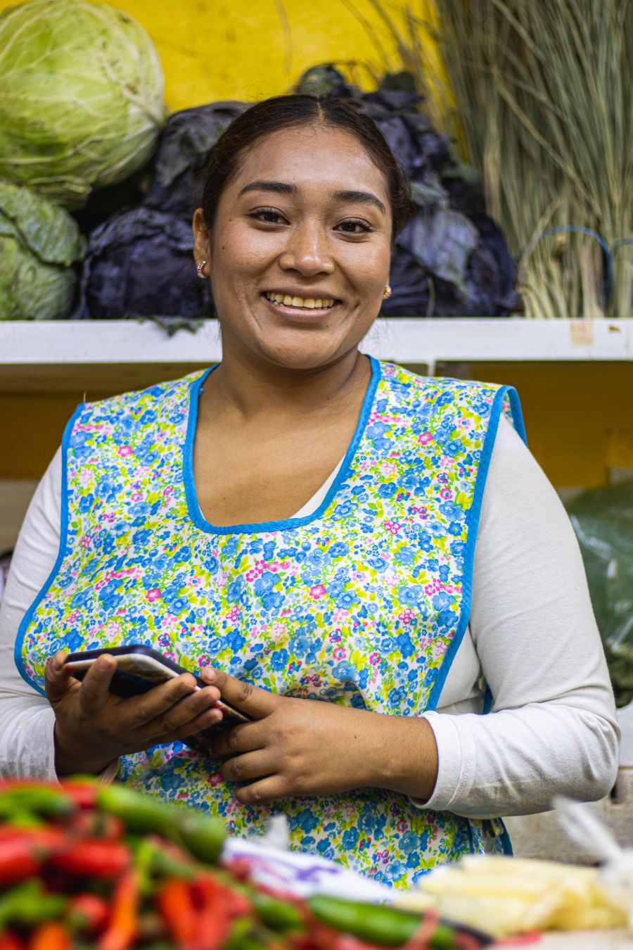 Vendedora de verduras sonriendo con su mandil